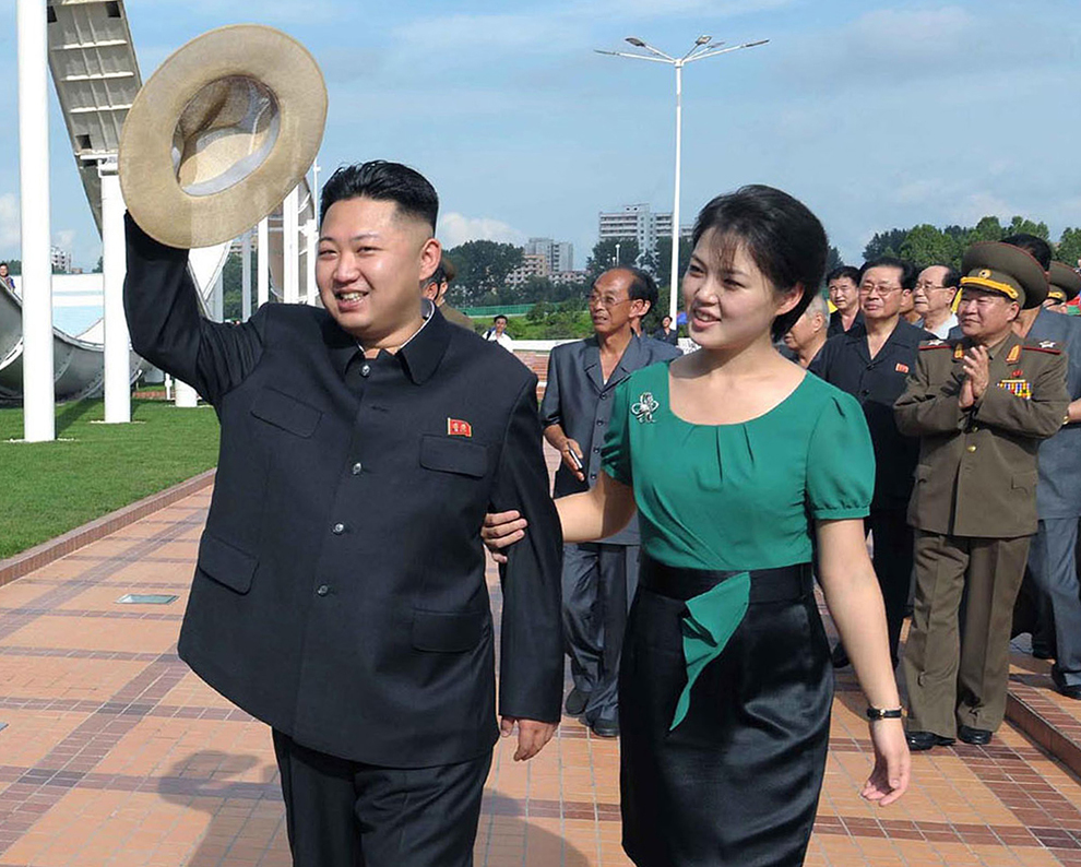 Liderul nord-coreean Kim Jong-un (S), alături de soţia sa, Ri Sol-Ju (D), gesticulează în timpul unei vizite organizate la parcul de distracţii Rungan din Phenian,  într-o imagine nedatată,  furnizată sâmbătă, 26 iulie 2012.