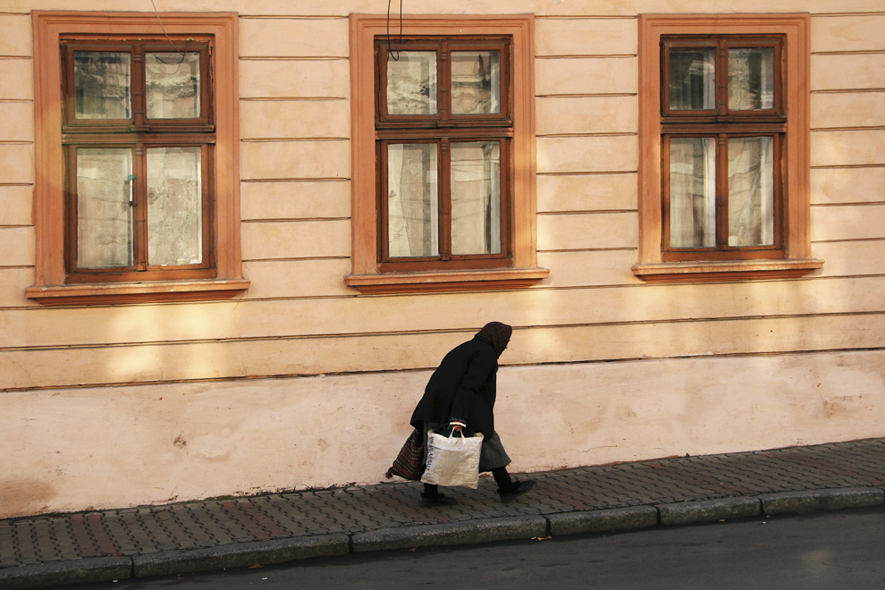O bătrână se grăbeşte pe o stradă din Cernăuţi.