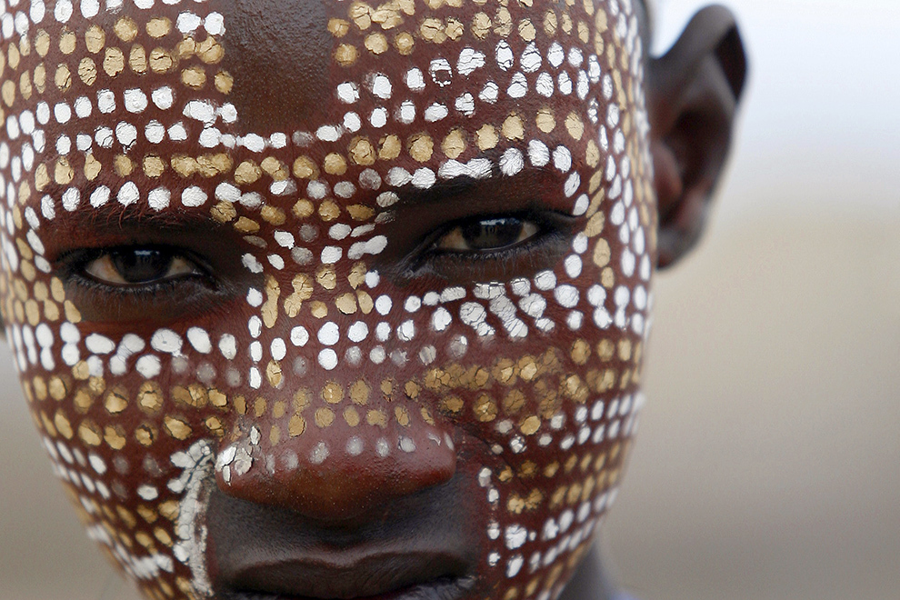 Un băiat din tribul Arbore de pe Valea râului Omo din sudul Etiopiei pozează purtând decoraţiuni tradiţionale pe piele.