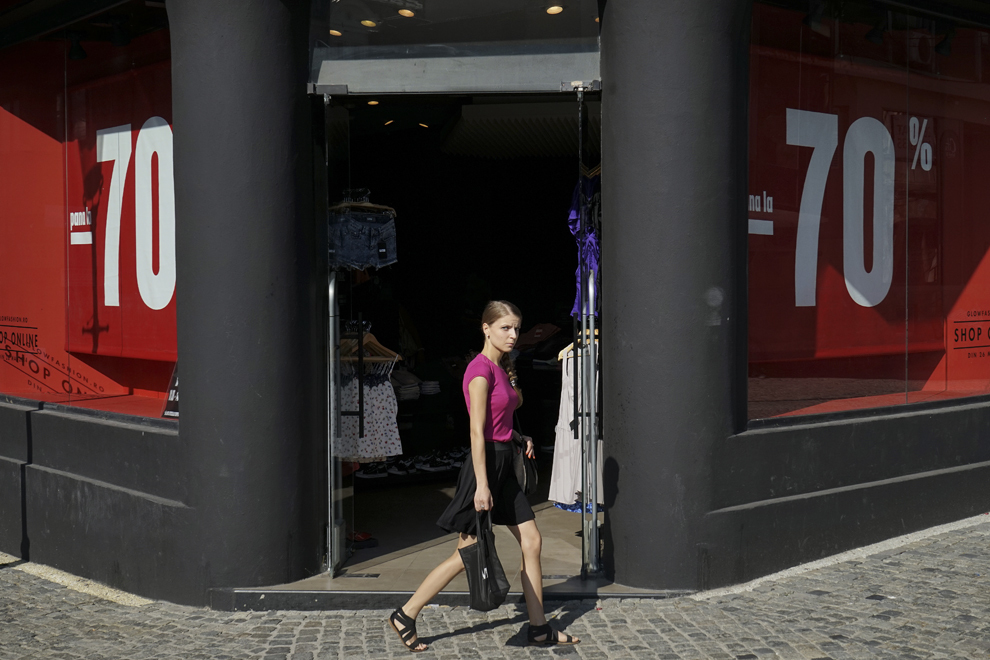 O tânără trece prin faţa magazinului „Glow”, în Centrul Vechi din Bucureşti, joi, 14 august 2014.