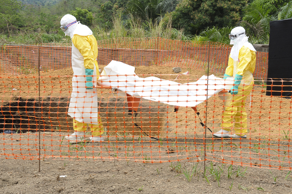 Personal medical din cadrul organizaţiei “Doctori fără frontiere” transportă cadavrul unei persoane decedate în urma infectării cu febră hemoragică virală, la un centru pentru victimele virusului Ebola, în Guekendou, Guineea, marţi, 1 aprilie 2014. Epidemia de febră hemoragică virală din Guineea este cauzată de mai mulţi viruşi ce au simptome similare, cel mai mortal virus fiind Ebola.