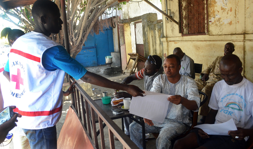 Membri ai organizaţiei Crucea Roşie din Guineea distribuie materiale cu informaţii în timpul unei campanii de conştientizare asupra virusului Ebola, în Conarky, Guineea, vineri, 11 aprilie 2014.  