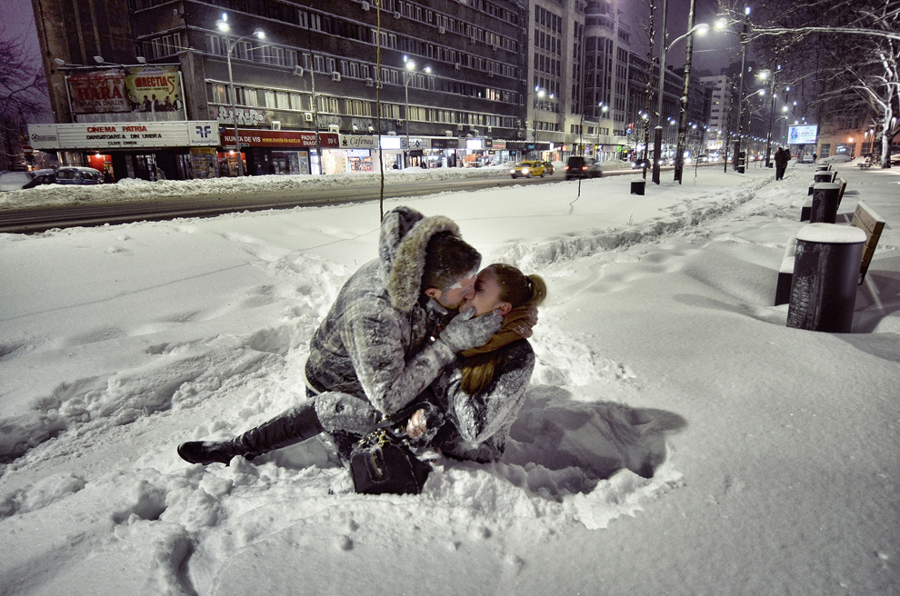 Doi tineri se sărută în zăpadă, pe bulevardul Magheru din Bucureşti, luni, 27 ianuarie 2014.