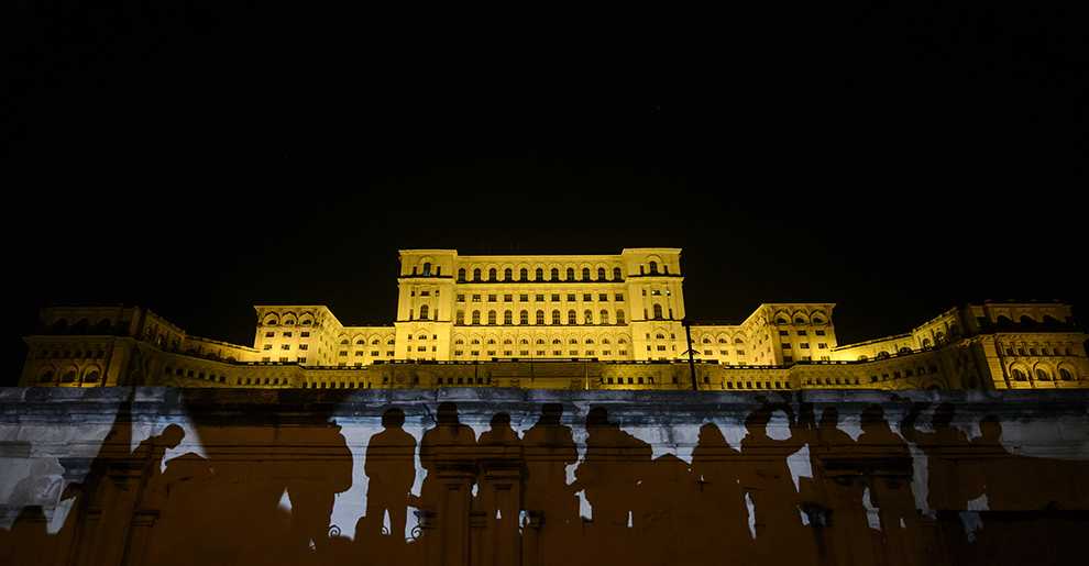 Umbrele protestatarilor sunt proiectate pe peretele unei intrari din Palatul Parlamentului, în timpul unui marş de protest împotriva clasei politice, în Bucureşti, miercuri, 4 noiembrie 2015. 