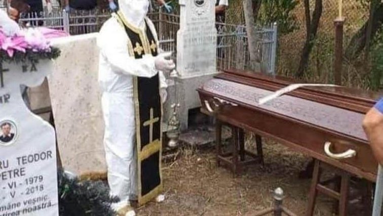 Imaginea articolului Un preot din Olt a oficiat slujba de înmormântare a unui bărbat mort de COVID-19, îmbrăcat în combinezon
