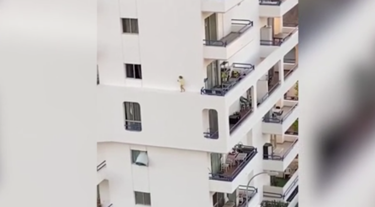 Imaginea articolului VIDEO: Momentul terifiant în care un copil începe să meargă pe bordura aflată la înălţime a unui bloc din Tenerife şi işi pierde echilibrul