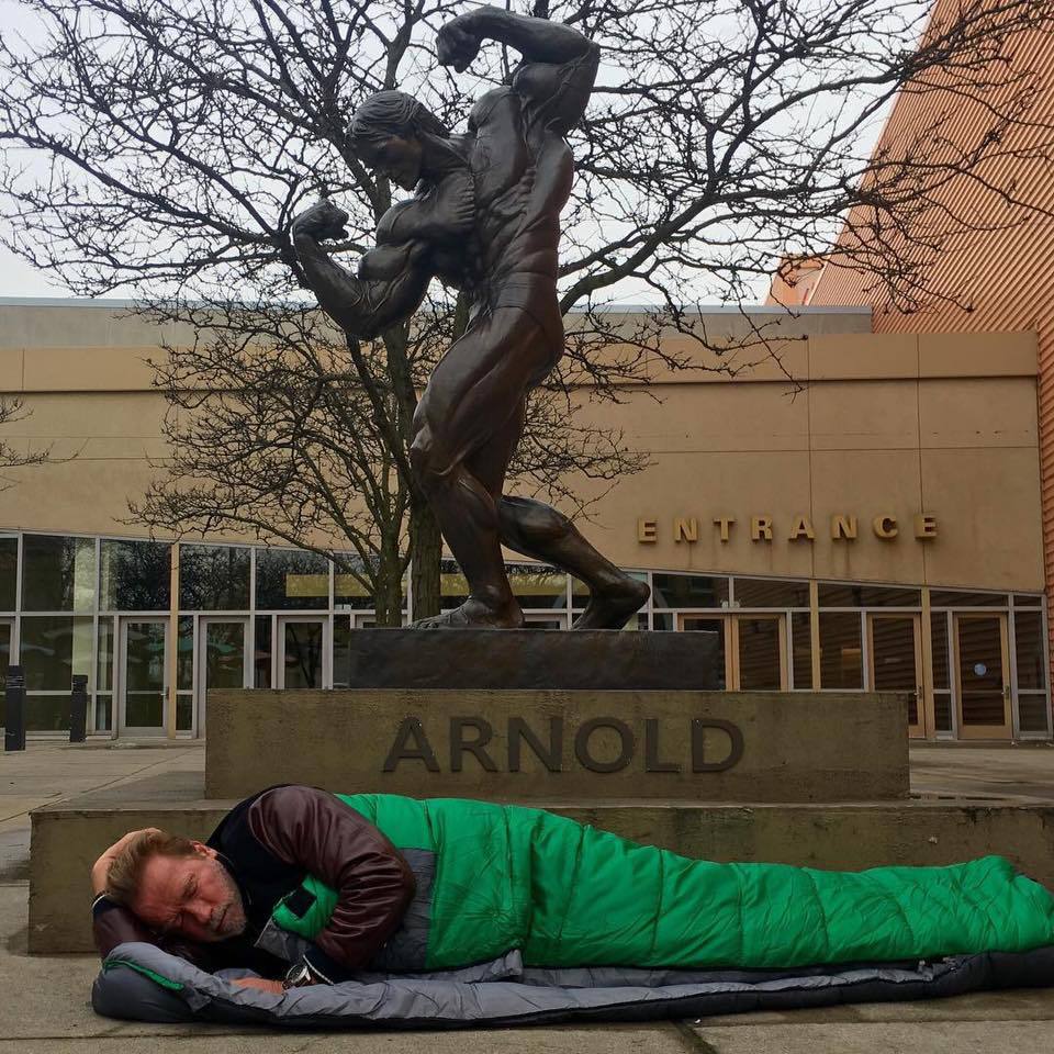 Arnold Schwarzenegger, fotografiat într-un sac de dormit, lângă statuia sa din Ohio 
